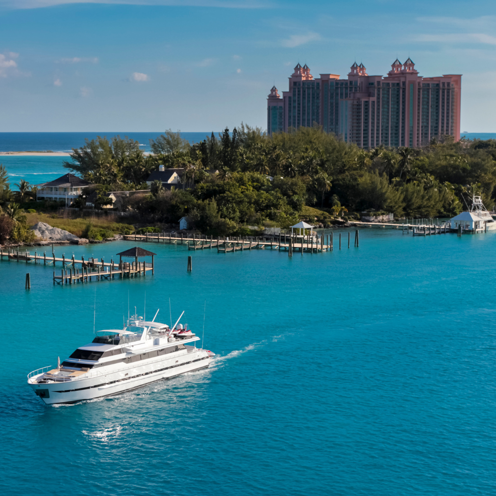 Luxury yacht anchored with the iconic Atlantis Hotel in the background, showcasing the allure of Bahamas yacht charters from Florida.