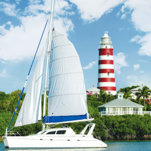 Scenic view of the Abaco Island lighthouse with a catamaran anchored in front.